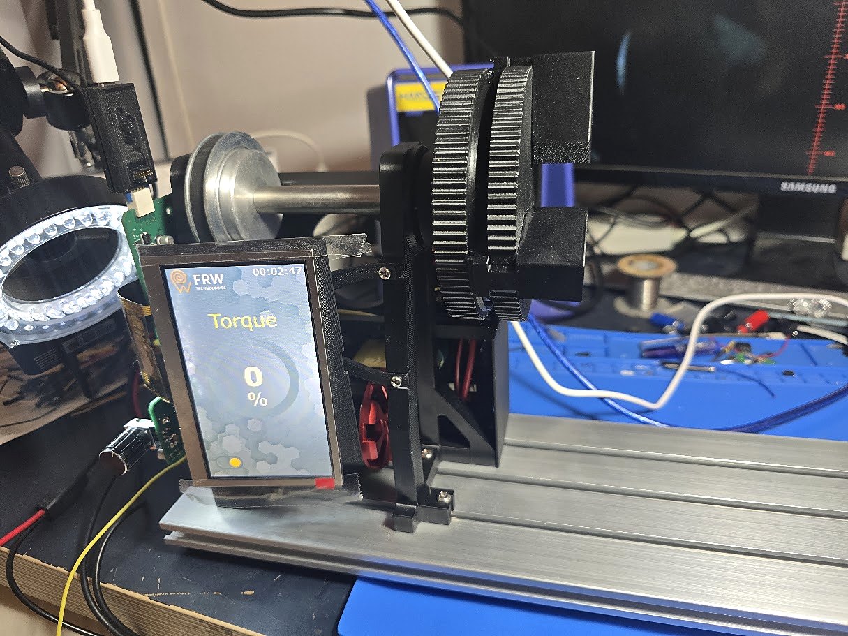 Early FRW4 prototype on a workbench with exposed electronics and a display showing the torque screen