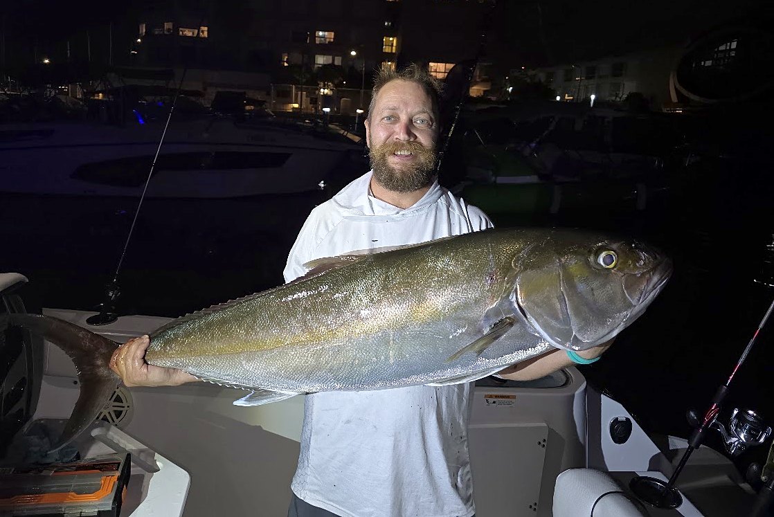 Alexander Gorin, co-founder of FRW4, on a boat at night holding a large fish